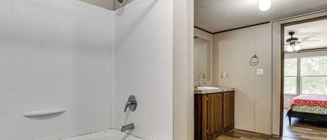 Un baño con bañera, ducha y lavamanos.