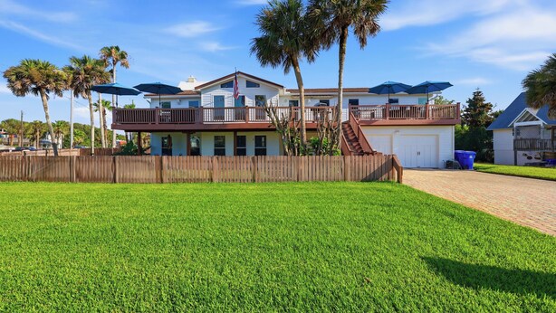 A two-story house with a balcony, a fenced yard, and palm trees. - Walk to the Beach! St. Augustine Group Retreat (St. Augustine)
