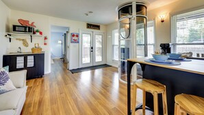 A modern kitchen with a central island, wooden flooring, and a view of the street. - Walk to the Beach! St. Augustine Group Retreat (St. Augustine)