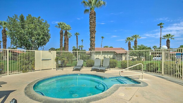A swimming pool with lounge chairs and a fenced area, surrounded by palm trees and a clear sky. - Steps to Empire Polo Club: Casita w/ Pool Access (Indio)