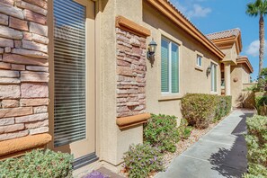 A residential building with a stone facade, a covered walkway, and a palm tree. - Steps to Empire Polo Club: Casita w/ Pool Access (Indio)