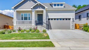 A two-story house with a front porch, a garage, and a well-maintained lawn. - Great for Families! Arvada Haven w/ Yard & Patio (Arvada)