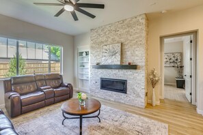 A living room with a leather sofa, a round coffee table, a fireplace, and a large window. - Great for Families! Arvada Haven w/ Yard & Patio (Arvada)