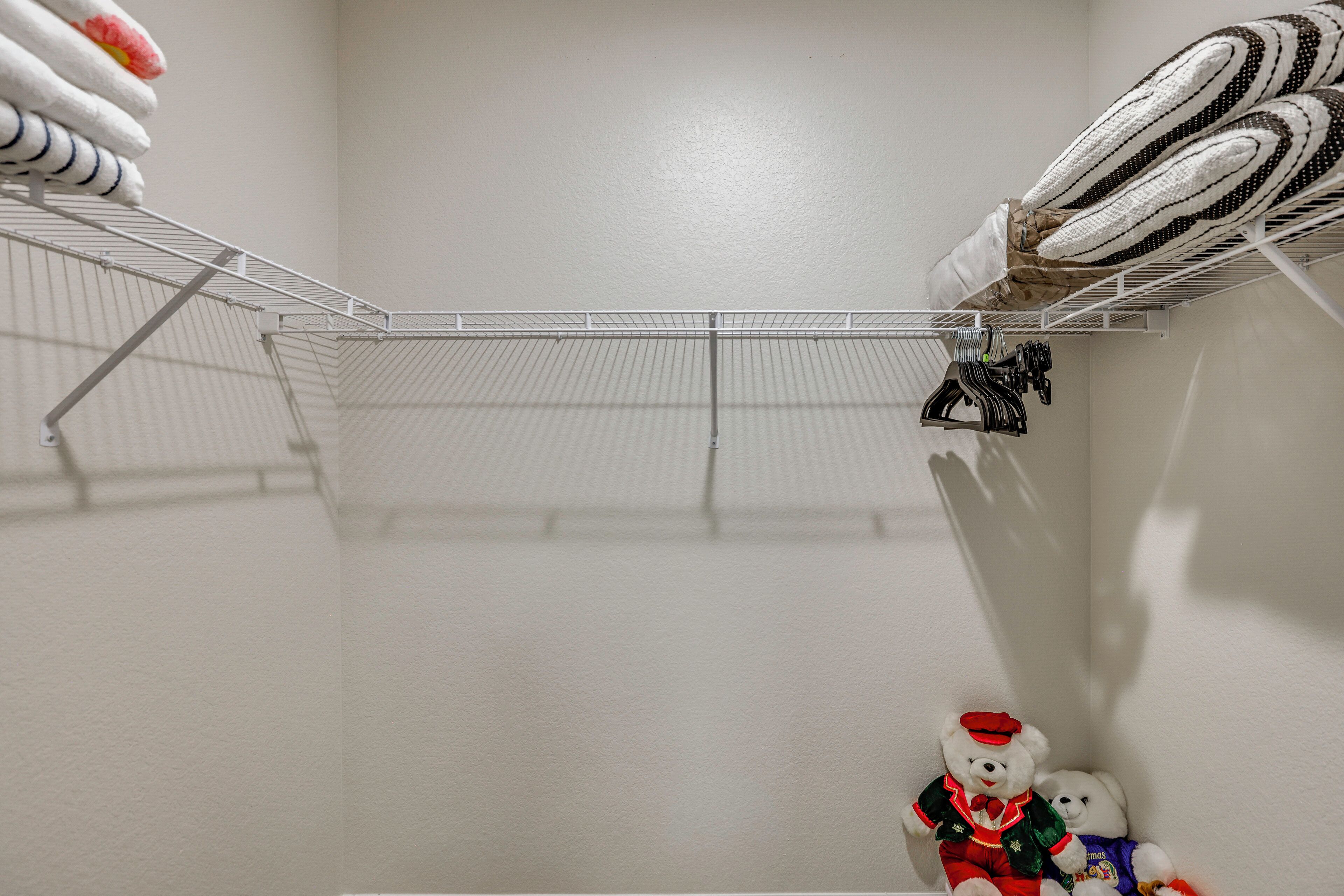A storage area with metal shelves and a hanging rack for towels.