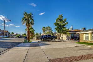 A residential street with houses, a parked truck, and a clear blue sky.