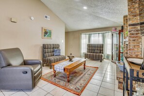 A living room with a sofa, armchair, and a coffee table.