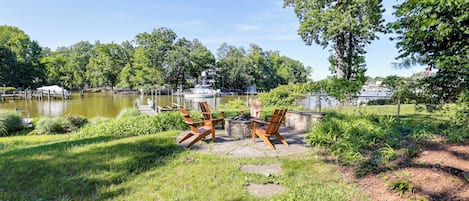 Un patio junto al lago con mobiliario exterior y vistas a barcos.