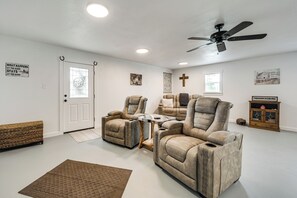A home theater room with two reclining chairs, a ceiling fan, and a wooden cabinet. - Great for Families! Fredericksburg Home w/ Hot Tub (Fredericksburg)