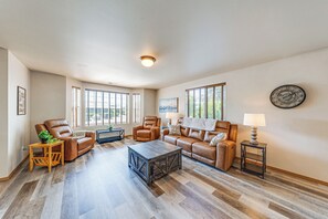 Un salón amplio con sofás de cuero, una mesa de centro y una chimenea.