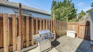 A backyard with a barbecue grill, a wooden fence, and a house. - Walk to Town! Charming La Conner Home (La Conner)