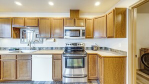 A kitchen with wooden cabinets, a stainless steel oven, a microwave, and a dishwasher. - Walk to Town! Charming La Conner Home (La Conner)