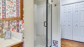 A bathroom with a shower, a sink, and a toilet.