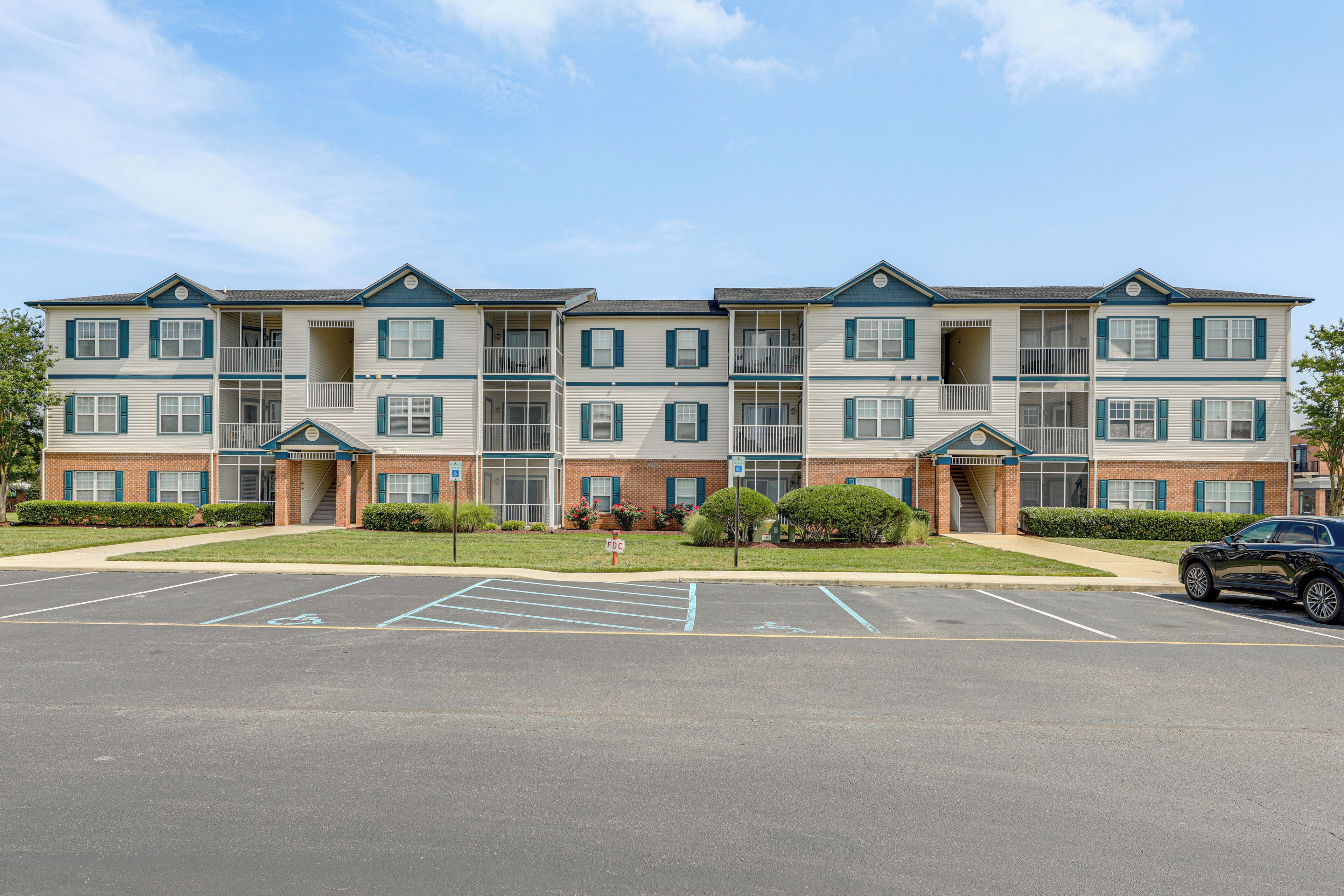 A multi-story building with a parking lot in front.
