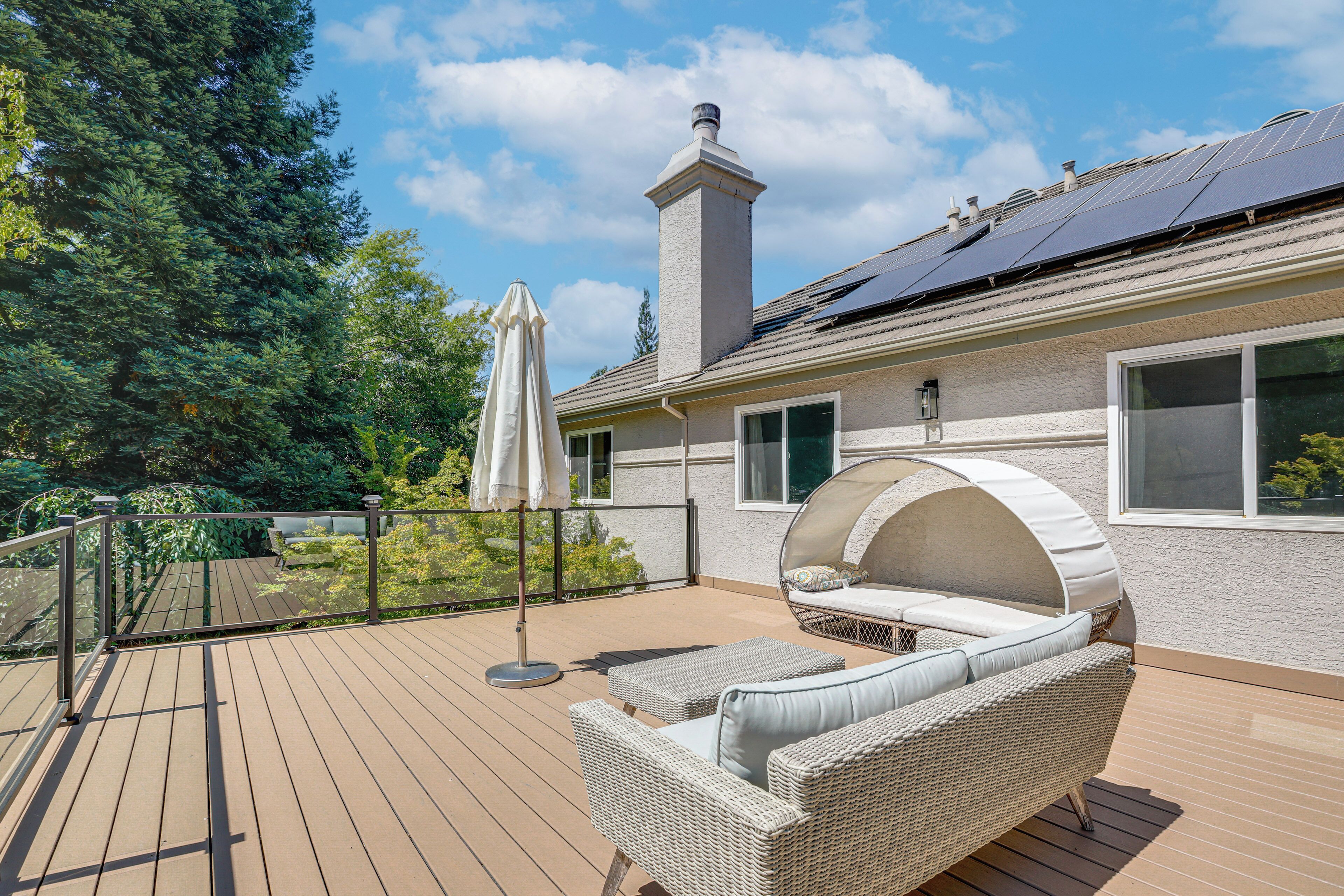 A deck with outdoor furniture, a covered seating area, and a chimney.