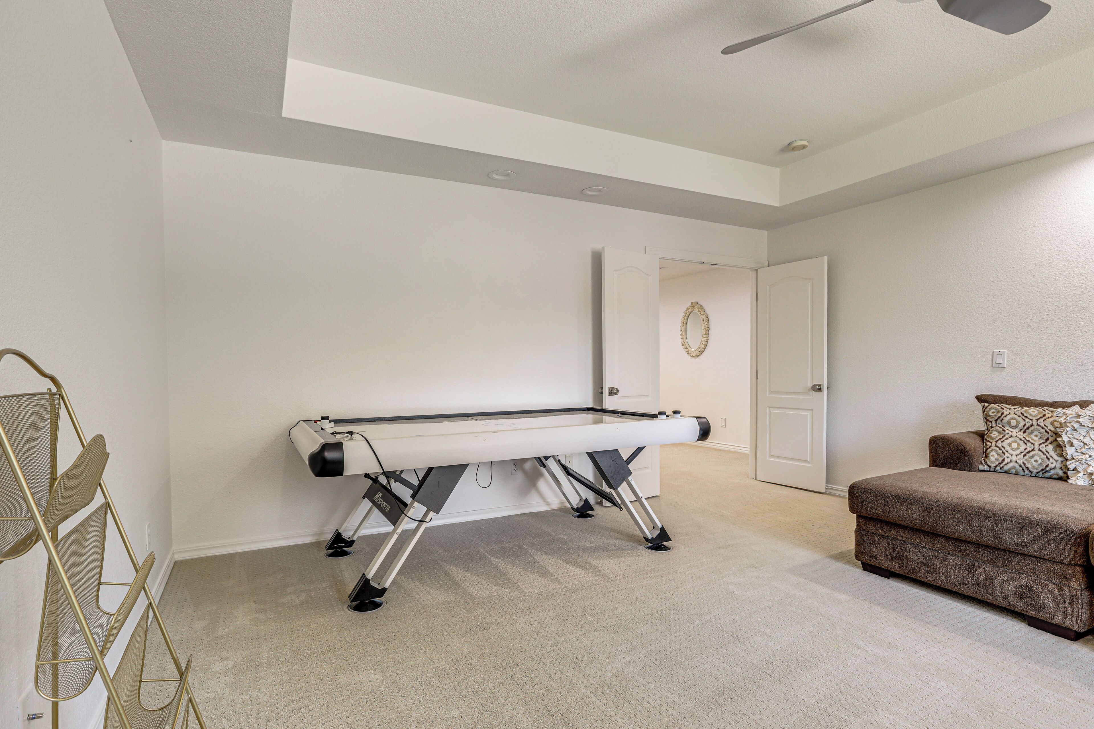 A room with a pool table, a couch, and a door.
