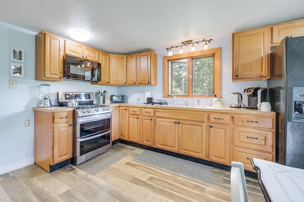 A kitchen with wooden cabinets, stainless steel appliances, and a window. - Creekside Retreat in Speedsville w/ Deck & Yard (Berkshire)