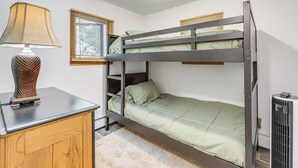 A bunk bed with a desk and lamp, a radiator, and a window with blinds. - Creekside Retreat in Speedsville w/ Deck & Yard (Berkshire)