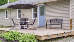 A house with a deck, a table with chairs, a bench, and an umbrella. - Creekside Retreat in Speedsville w/ Deck & Yard (Berkshire)