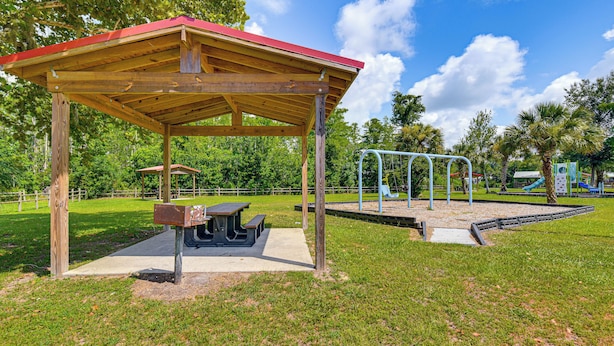 A park with a wooden pavilion, picnic tables, and playground equipment.