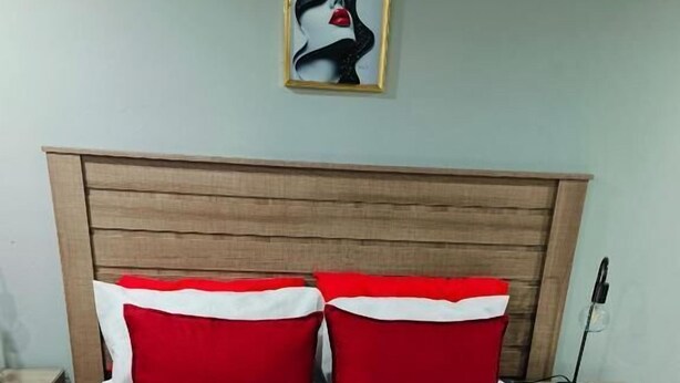 A bed with white bedding, red pillows, and a red throw blanket. - Room-acama Guest House 455 Long rd, Welk (Matjhabeng)