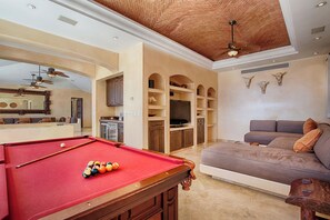 A pool table with balls, a sofa, a television, and a ceiling fan in a room with a brick ceiling. - Luxury Pedregal Villa Pairing with Stunning Ocean Views (Cabo San Lucas)