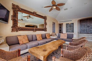 A spacious living area with a large ornate mirror, a ceiling fan, and a modern sofa set. - Luxury Pedregal Villa Pairing with Stunning Ocean Views (Cabo San Lucas)