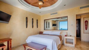 Ein Schlafzimmer mit einem Bett, einem Fernseher, einem Deckenventilator und einem Fenster mit Blick.