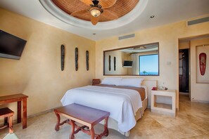 A bedroom with a bed, a television, a ceiling fan, and a window with a view. - Luxury Pedregal Villa Pairing with Stunning Ocean Views (Cabo San Lucas)