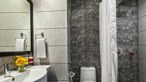 Een badkamer met een wastafel, spiegel, toilet en douchegordijn.