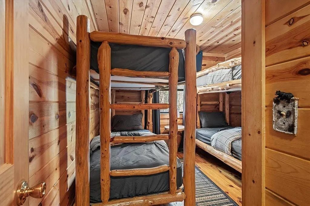 Ein Holzblockhaus-Innenraum mit Etagenbetten und einer Tür.