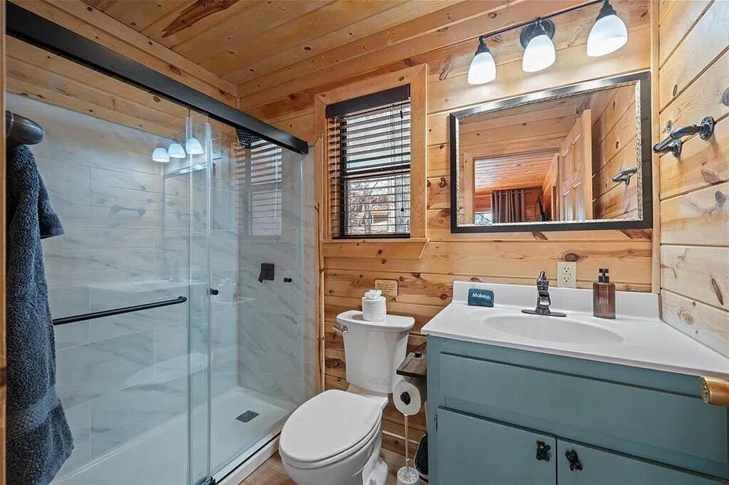 Freshen up in your beautifully appointed bathroom with modern fixtures, a spacious walk-in shower, and charming rustic wood accents that bring warmth to your stay.