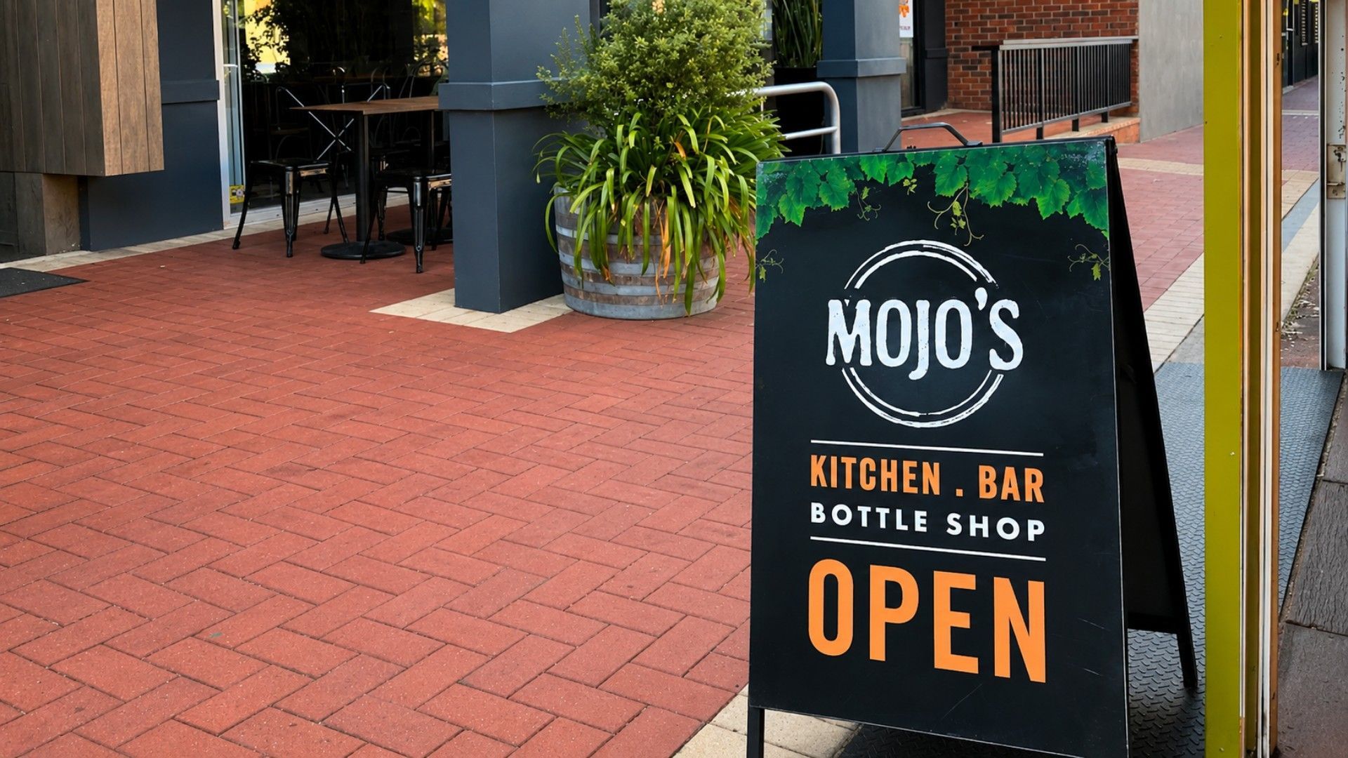 A signboard for 'MOJO'S KITCHEN. BAR BOTTLE SHOP' indicating it is OPEN.