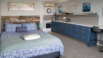 A bedroom with a bed, a bedside table, a clock, and a wall-mounted shelf with jars.