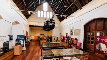 An interior with wooden floors, a glass display case, and a high ceiling with exposed beams.