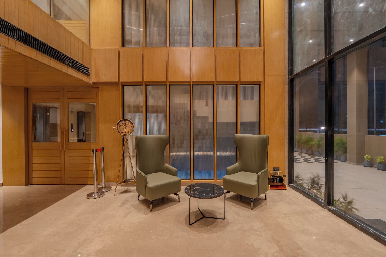 A lobby with two armchairs, a clock, and a small table.