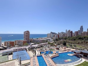 A resort with a pool, tennis courts, and a view of the city and ocean. - Modern apartment with sea view - 4 guests (Benidorm)