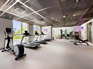 A gym with treadmills, a stationary bike, and weight machines. - Boho-Chic 1BR w/ Pool | Dubai Hills (Dubai)