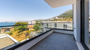 A balcony with a clear view of the sea and a hilly landscape. - Bella Vista Balcony 1BR Apartment (Vlorë)