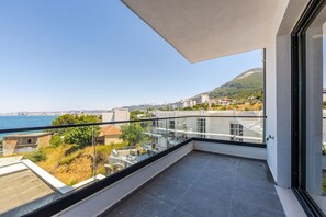 A balcony with a clear view of the sea and a hilly landscape. - Bella Vista Balcony 1BR Apartment (Vlorë)