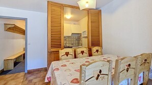 Una habitación con una cama de madera, una mesa y una silla con respaldos con forma de corazón.
