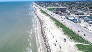 Vista aérea de uma cidade costeira com praia, ruas e edifícios.