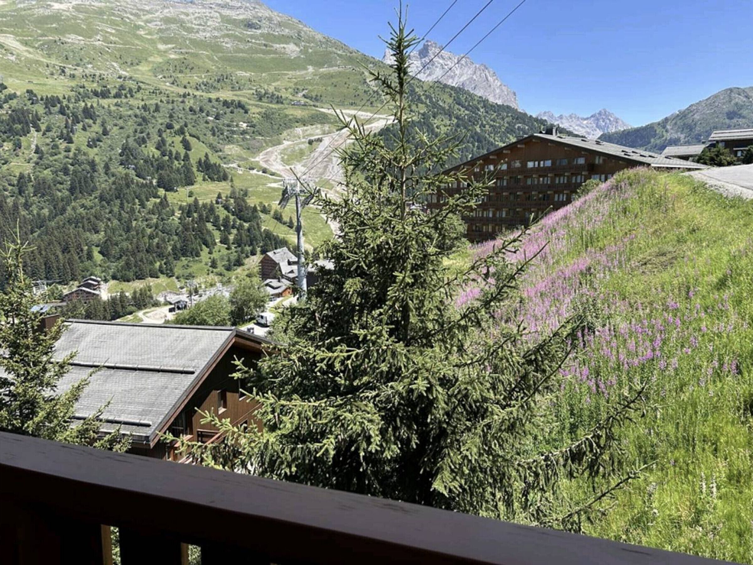 Uma pousada na montanha com vista para um vale e montanhas ao longe.