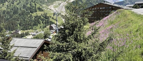 Una cabaña de montaña con vista a un valle y montañas distantes.