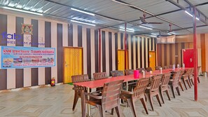 A conference room with a long table, chairs, and a banner advertising hotel tours. - Hotel Shree Ram Adhar (Ayodhya)
