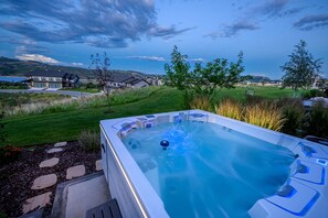 Uma banheira de hidromassagem em um quintal com vista para casas e colinas.