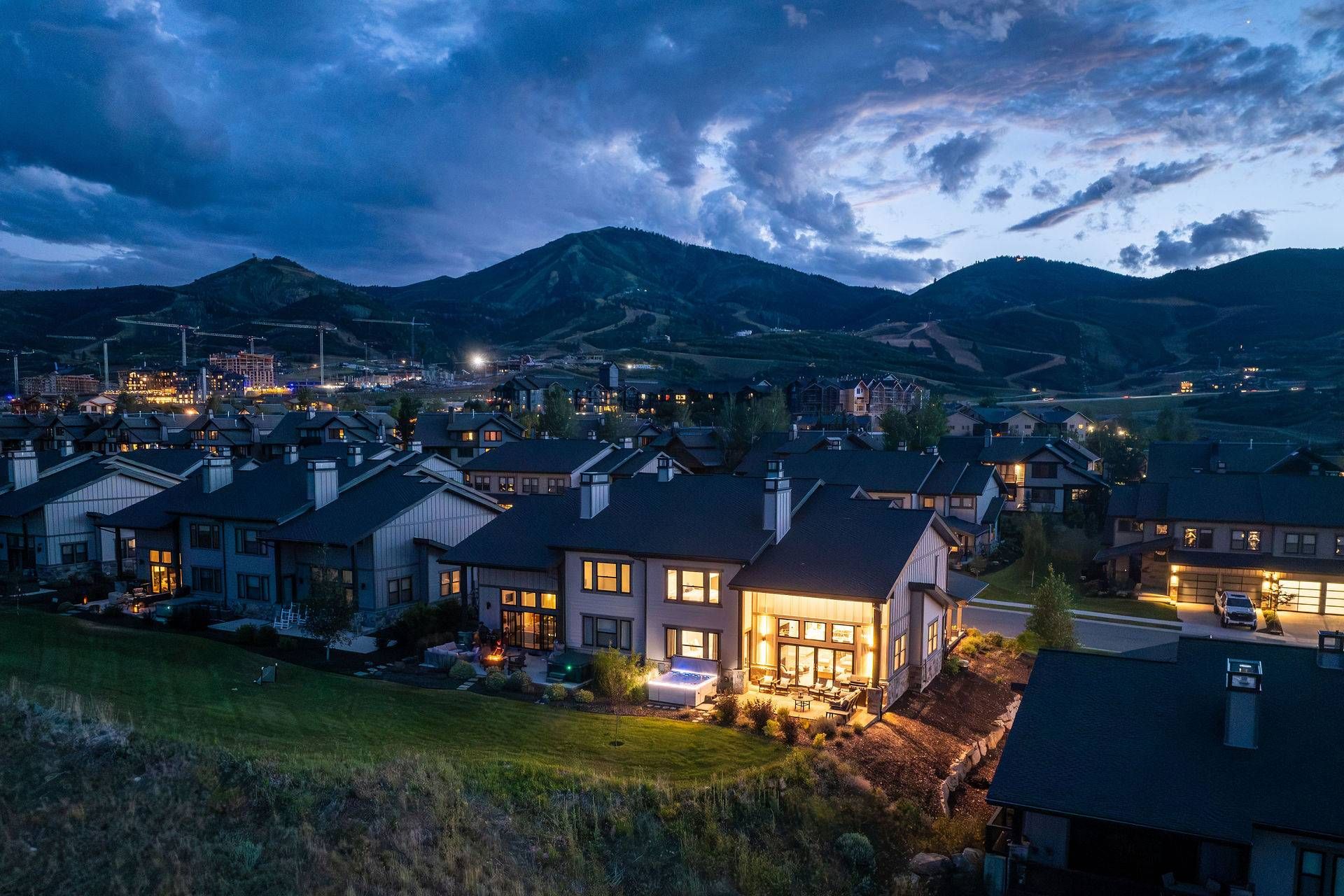 Área residencial com casas, uma estrada visível e uma cordilheira ao fundo.