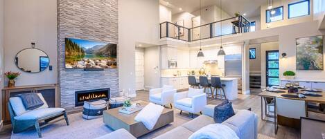 A spacious living area with a fireplace, comfortable seating, a kitchen, and a dining area.