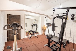 A gym with exercise equipment, a door, and a mirror reflecting the room. - Villa Dalmatia Luxury Stone Villa With Pool & Tennis (Sveti Filip i Jakov)
