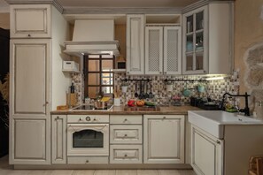 Eine Küche mit weißen Schränken, einem eingebauten Backofen und einer gefliesten Spritzschutzwand.