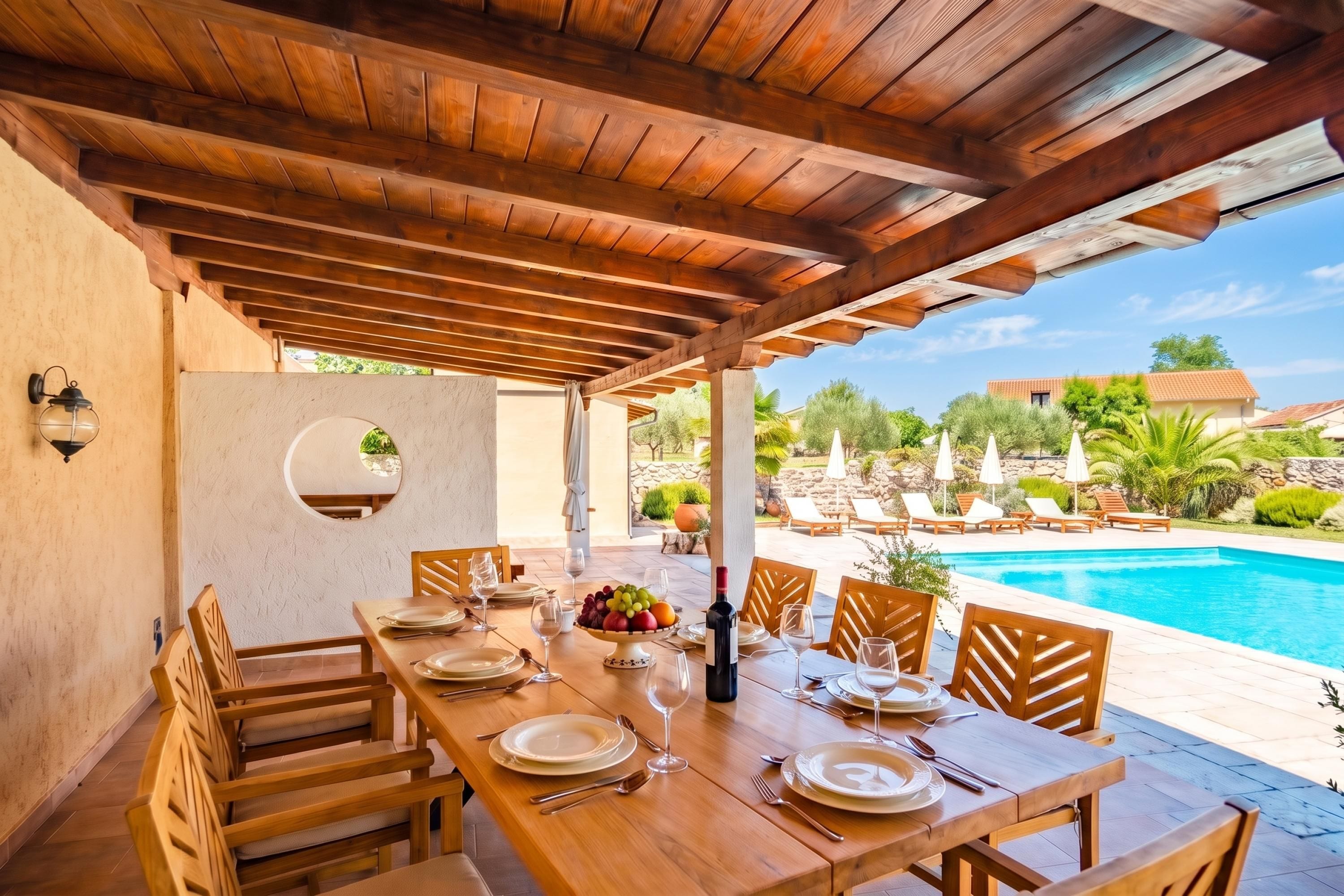 An outdoor dining area with a pool view, wooden tables, and chairs.